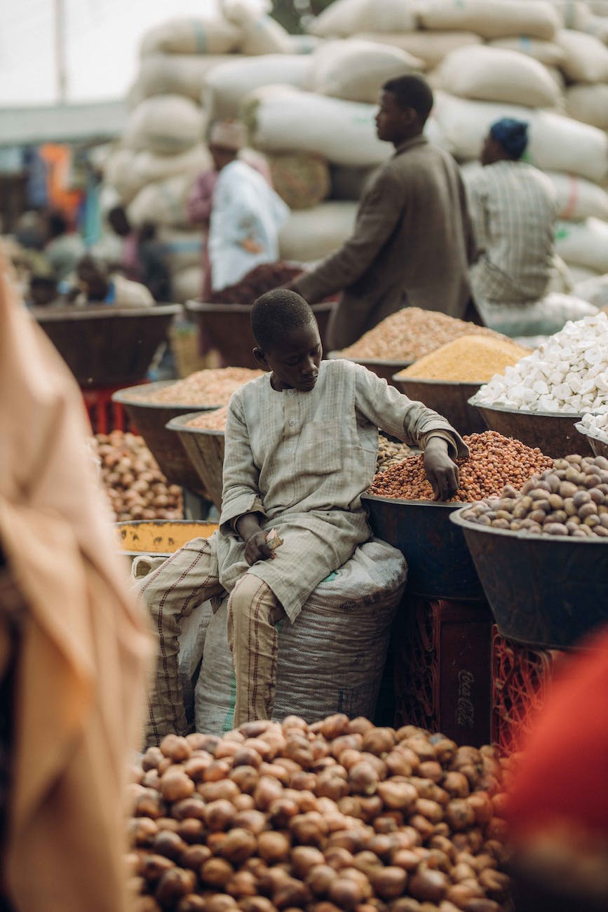 boy sitting on sack on outdoor market